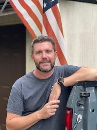 Chuck, owner of Tarboro Electric LLC, leaning beside his truck