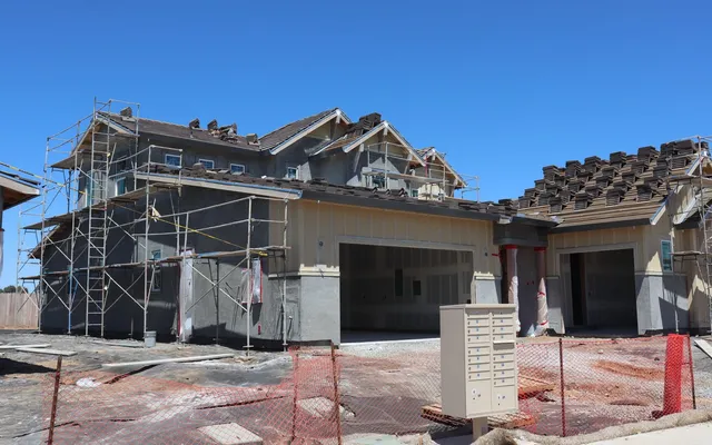 A new home under construction with scaffolding around its exterior.