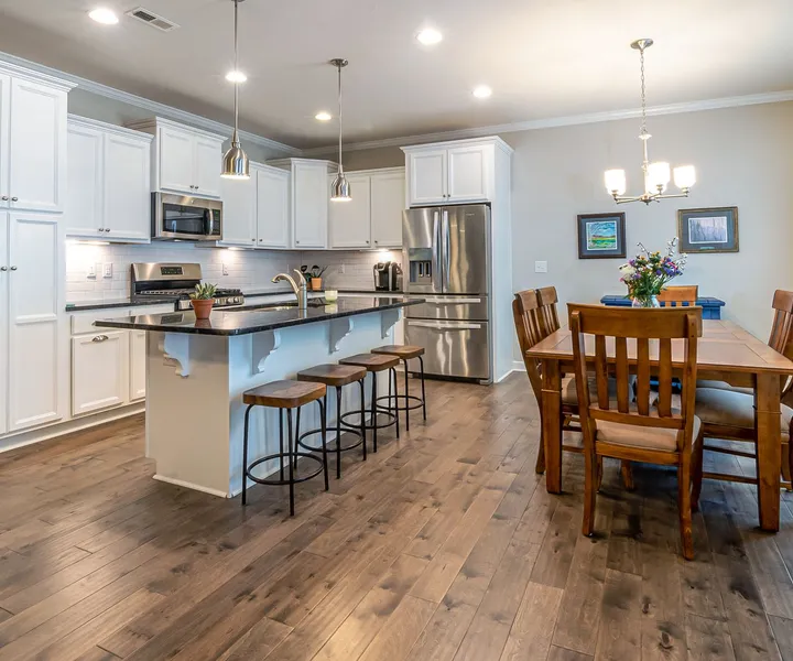 A bright kitchen with pendant lights, recessed lights and under-cabinet lighting